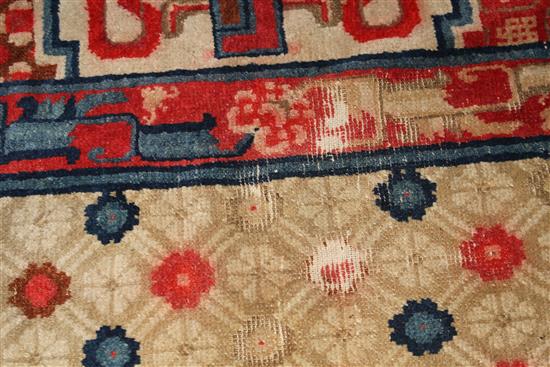 A small Chinese Suiyvan carpet, the fawn ground field woven with a lattice pattern, each cross centred by flowerheads, within a border